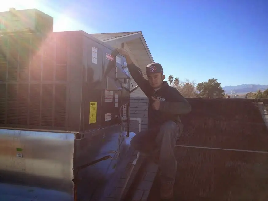 HVAC technician performing Heat Pump Repair on a rooftop unit in Newport